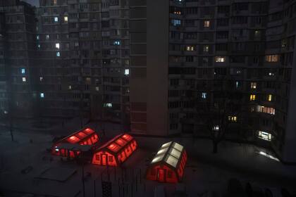 Tiendas de campaña de emergencia se instalan en un barrio residencial donde la gente puede protegerse del frío tras los frecuentes ataques aéreos rusos contra las centrales energéticas del país, que dejan a los residentes sin electricidad, agua ni calefacción en pleno invierno, en Kiev