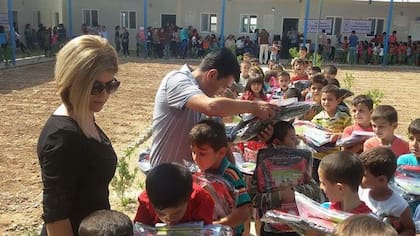 Tima y Abdullah reparten ropa comprada por la Fundación en un campo de refugiados en Irak