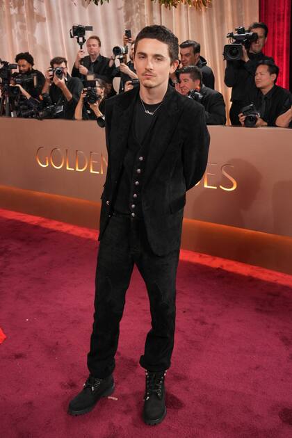 Timothée Chalamet, nominado a mejor actor por su labor en Marty Supremo, apareció con un conjunto negro de terciopelo compuesto por un saco, un chaleco y pantalones metidos dentro de las botas. Si bien no desfiló por la alfombra roja, junto a él llegó su novia, Kylie Jenner