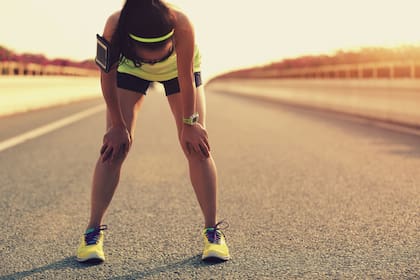 tired woman runner taking a rest after running hard on city road
