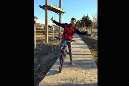 Tiziano, con sonrisa completa, con la bicicleta nueva que le donaron para que pueda ir a la escuela