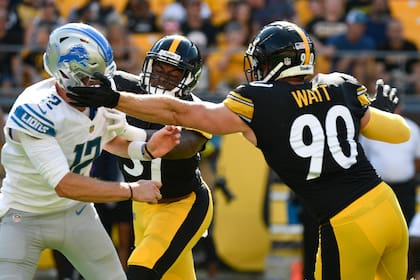 T.J. Watt (90), linebacker de los Steelers de Pittsburgh, coloca una mano sobre el casco del quarterback Tim Boyle (12) de los Lions de Detroit mientras lo presiona durante la primera mitad del juego de pretemporada de la NFL, el domingo 28 de agosto de 2022, en Pittsburgh. No se marcó castigo en la jugada. (AP Foto/Don Wright)