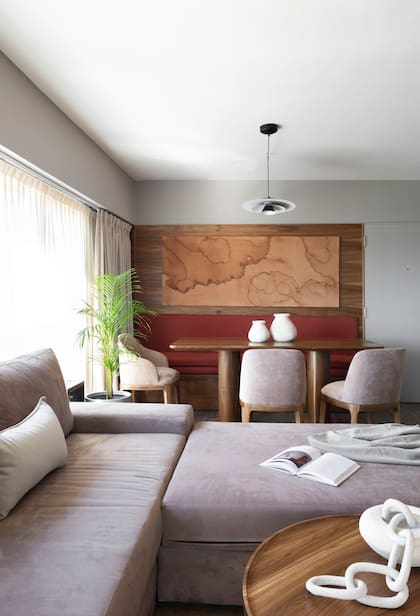 “Toda la casa maneja una paleta muy neutra y el quiebre visual de ese sector lo resolvimos agregando una colchoneta de un color rojo potente sobre el banco de madera, logrando un elemento que rompe la monocromía".