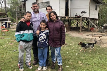 Toda la familia Villalba completa, con la casa que construyeron entre todos de fondo; el sueño es poder tener un cuarto más para estar menos apretados