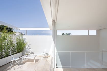 Todas las barandas de hierro fueron diseñadas por el estudio MichatekSkarstad y soldadas en obra. La mesada de la vieja cocina se recicló como tapa de la mesita exterior.