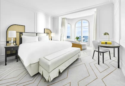 Todas las habitaciones que dan al mar se ampliaron con tonos blancos y neutros y cabeceras de mimbre.