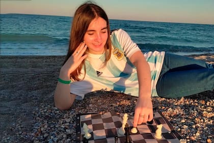 Todo disfrute para Candela Francisco: camiseta argentina, playa y ajedrez; a los 16 años, conquistó el Campeonato Continental y aspira a ser campeona del mundo.