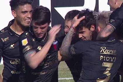 Todos abrazan a Cristian Ferreira, autor del gol de tiro libre con que Colón le ganó a Godoy Cruz en Santa Fe