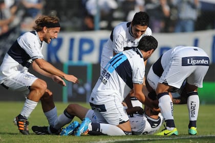 Todos abrazan a Licht, en el piso, que acaba de marcar un golazo de chilena