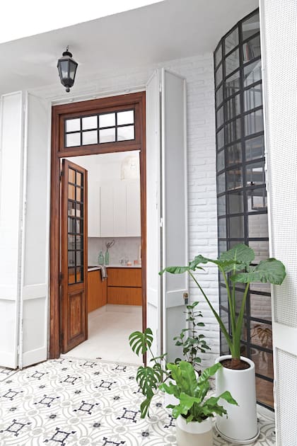 Todos los ojos al piso: granítico en la cocina y calcáreo de base blanca en el patio, para una transición suave.