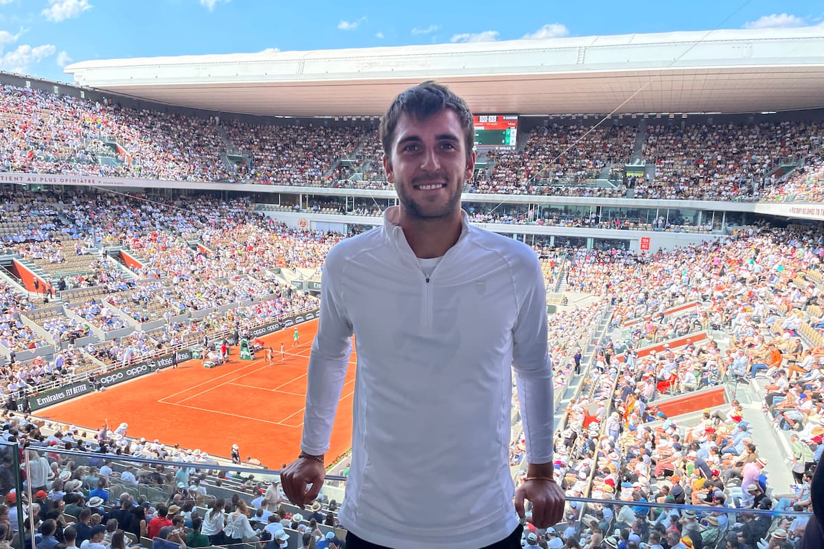 Tomás Etcheverry, con LA NACION, en el lugar de los sueños; de fondo, el estadio Philippe Chatrier a pleno mientras juegan Djokovic y Khanachov