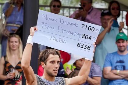 Tomás Etcheverry sostiene un cartel con la diferencia de puntos entre él y Djokovic