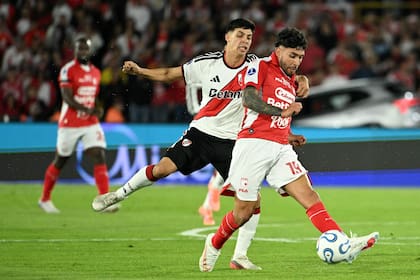 Tomás Galván agarra a Nahuel Bustos, que lleva la pelota