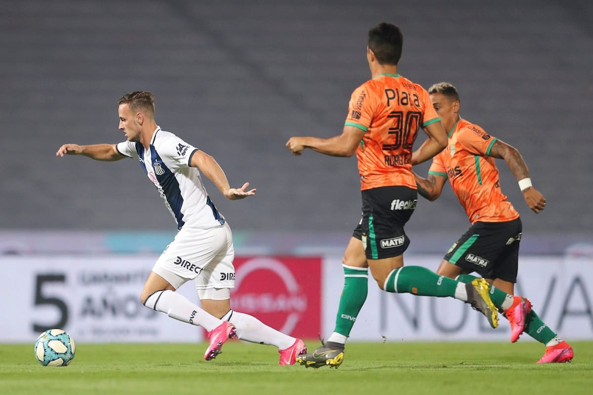 Tomás Pochettino, de Talleres, elude a dos jugadores de Banfield.