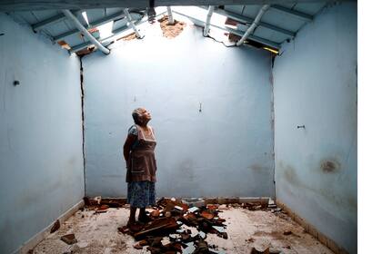 Tomasa Mozo, de 69 años, ama de casa, mira hacia el techo mientras posa para un retrato dentro de las ruinas de su casa después del terremoto en San José Platanar