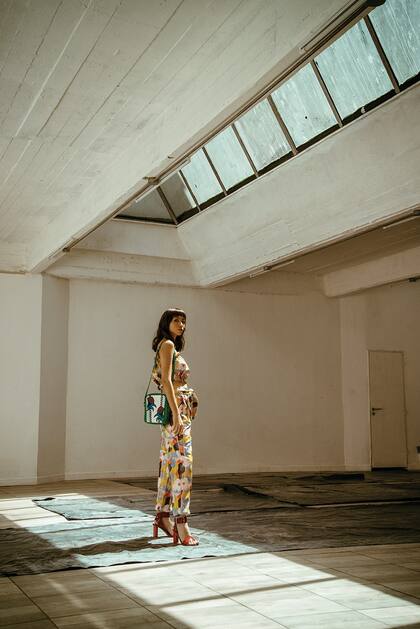 Top asimétrico y pantalón estampados y cartera de cuero (Jazmín Chebar), sandalias de charol (Mishka)