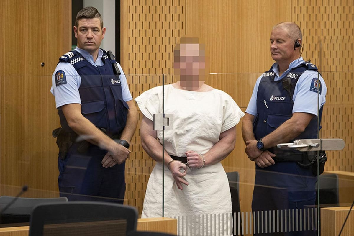 TOPSHOT - Brenton Tarrant, the man charged in relation to the Christchurch massacre, makes a sign to the camera during his appearance in the Christchurch District Court on March 16, 2019. - A right-wing extremist who filmed himself rampaging through two mosques in the quiet New Zealand city of Chris