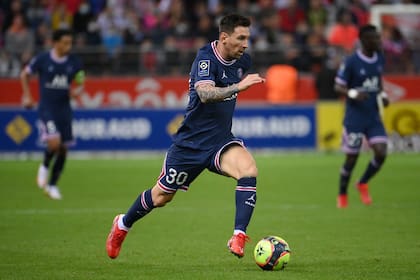 TOPSHOT - Paris Saint-Germain's Argentinian forward Lionel Messi runs with the ball during the French L1 football match between Stade de Reims and Paris Saint-Germain (PSG) at Stade Auguste Delaune in Reims, northern France on August 29, 2021. (Photo by FRANCK FIFE / AFP)