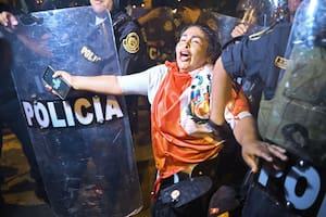 TOPSHOT - Policemen grab a woman during a demonstration against the government of Peruvian President Dina Boluarte in Lima on January 31, 2023. - Protesters who have brought parts of Peru to a standstill for weeks closed in on Lima's international airport Tuesday as lawmakers mulled bringing elections forward in a bid to end the deadly mobilization. The South American country has been embroiled in a political crisis with near-daily demonstrations since December 7, when then-president Pedro Castillo was arrested after attempting to dissolve Congress and rule by decree. (Photo by ERNESTO BENAVIDES / AFP