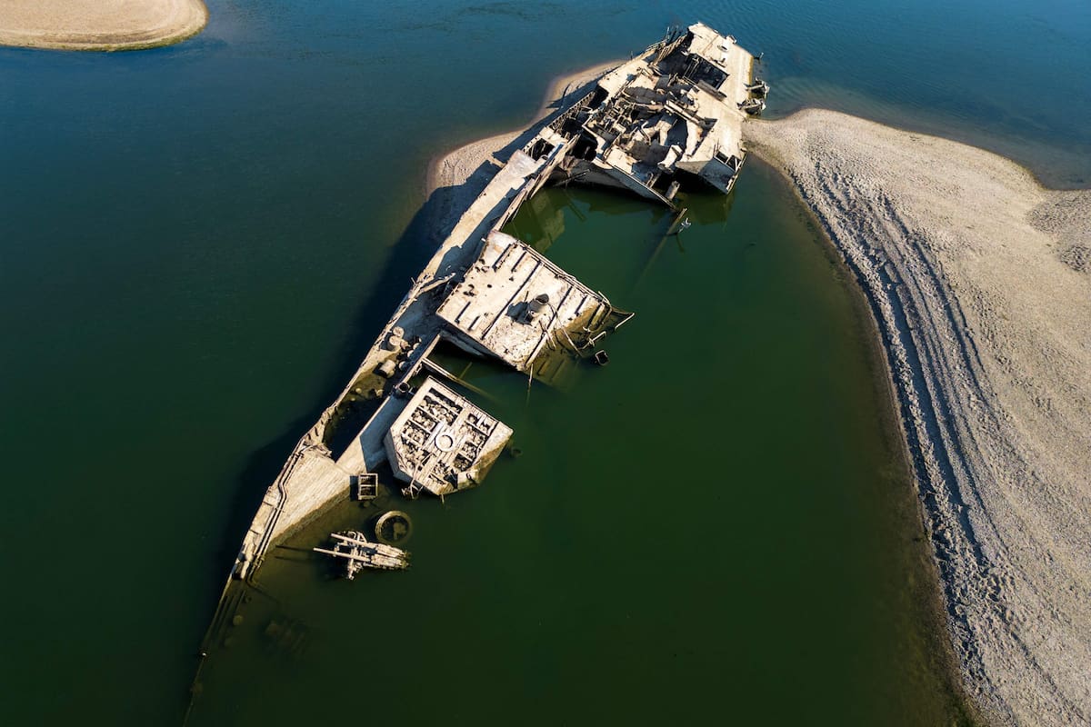 TOPSHOT - This aerial photograph shows the wreckage of a World War II German warship, one of dozens sunk by retreating Nazi forces in September 1944, emerging from the low waters of the Danube River near Prahovo, Serbia, on August 11, 2026, as drought and prolonged hot and dry weather continues to lower water levels across the region. Heat and drought are driving rivers across Europe to record lows. Low levels along the Danube river have already seen Hungary and Romania forced to consider shuttering their nuclear plants, which rely on the water for cooling, in late July, though both managed to avoid doing so for now. (Photo by Andrej ISAKOVIC / AFP)
