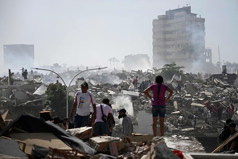 TOPSHOT - Volunteers search for possible victims in a collapsed building following twin earthquakes in Caraballeda, La Guaira state, some 40 km northeast of Caracas, on June 25, 2026. The death toll from twin quakes, measured at magnitudes 7.2 and 7.5, has risen to at least 188, with more than 1,520 others injured, top lawmaker Jorge Rodriguez reported, while residents continue searching for missing relatives. (Photo by Federico PARRA / AFP)