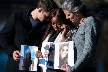 Tor Stumo, Zipporah Kuria Waithaka y Nadia Milleron sostienen fotos de los miembros de su familia que perdieron en el accidente de Ethiopian Airlines