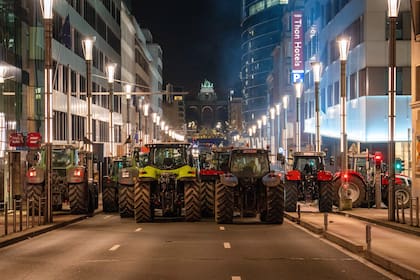 Trabajadores agrarios manejan sus tractores por una gran avenida durante una reunión de líderes europeos en la cumbre de la UE en Bruselas