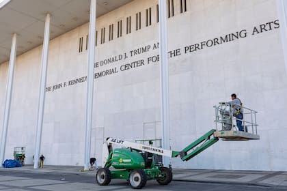 Trabajadores agregan el nombre del presidente Donald Trump al Centro Conmemorativo John F. Kennedy para las Artes Escénicas, después de que una junta designada por Trump votara para cambiar el nombre de la institución, en Washington, el 19 de diciembre de 2025.