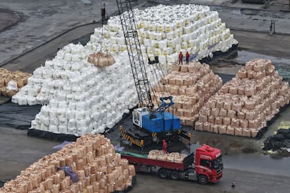 Trabajadores cargan bolsas de azufre sólido importado en un camión en un puerto de Nanjing, en la provincia oriental china de Jiangsu