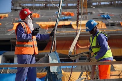 Trabajadores de la construcción en el estadio icónico de Lusail en Doha, Qatar.