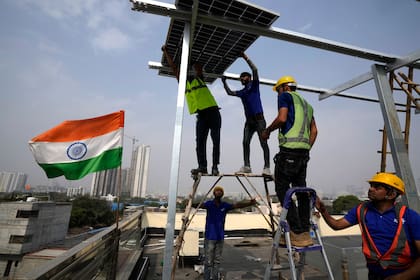 Trabajadores de la empresa Solar Square colocan un panel solar en el techo de una residencia en la ciudad de Gurugram, el martes 20 de febrero de 2024, en las afueras de Nueva Delhi, India. (AP Foto/Manish Swarup)