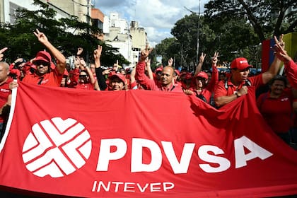 Trabajadores de la petrolera estatal venezolana PDVSA participan en una marcha convocada por el Partido Socialista Unido de Venezuela (PSUV) en apoyo a la Ley de Hidrocarburos y para exigir la liberación del presidente depuesto Nicolás Maduro, en Caracas