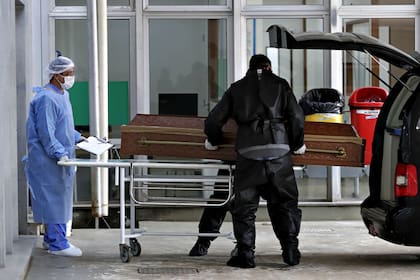 Trabajadores de la salud trasladan un ataúd en el Hospital Universitario de Brasilia