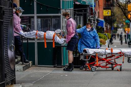 Trabajadores de la salud trasladan un paciente de Harlem a un hospital local