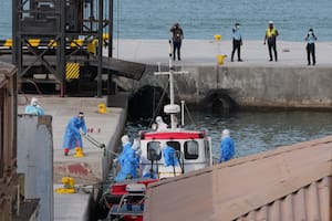 Trabajadores de salud con equipo de protección evacúan a pacientes del crucero MV Hondius en un puerto de Praia, en Cabo Verde, el miércoles 6 de mayo