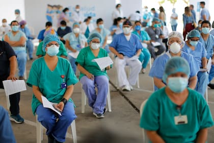 Trabajadores de salud peruanos de Lima hacen cola para recibir la primera dosis de la vacuna contra el coronavirus. Cerca de 500 personas recibieron la vacuna meses antes que ellos y que otros sectores de riesgo, favorecidos por su cercanía al poder
