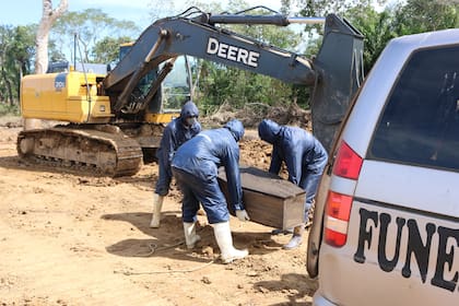 Trabajadores de una funeraria de Bolivia levantan un ataúd para llevarlo a una fosa recién cavada en Beni para víctimas de covid19. Crédito: Ricardo Gutiérrez