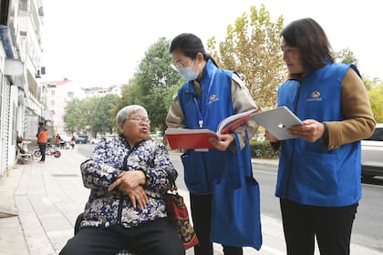 Trabajadores del censo recopilan información de una residente de Lianyungang, en la provincia de Jiangsu, en el este de China