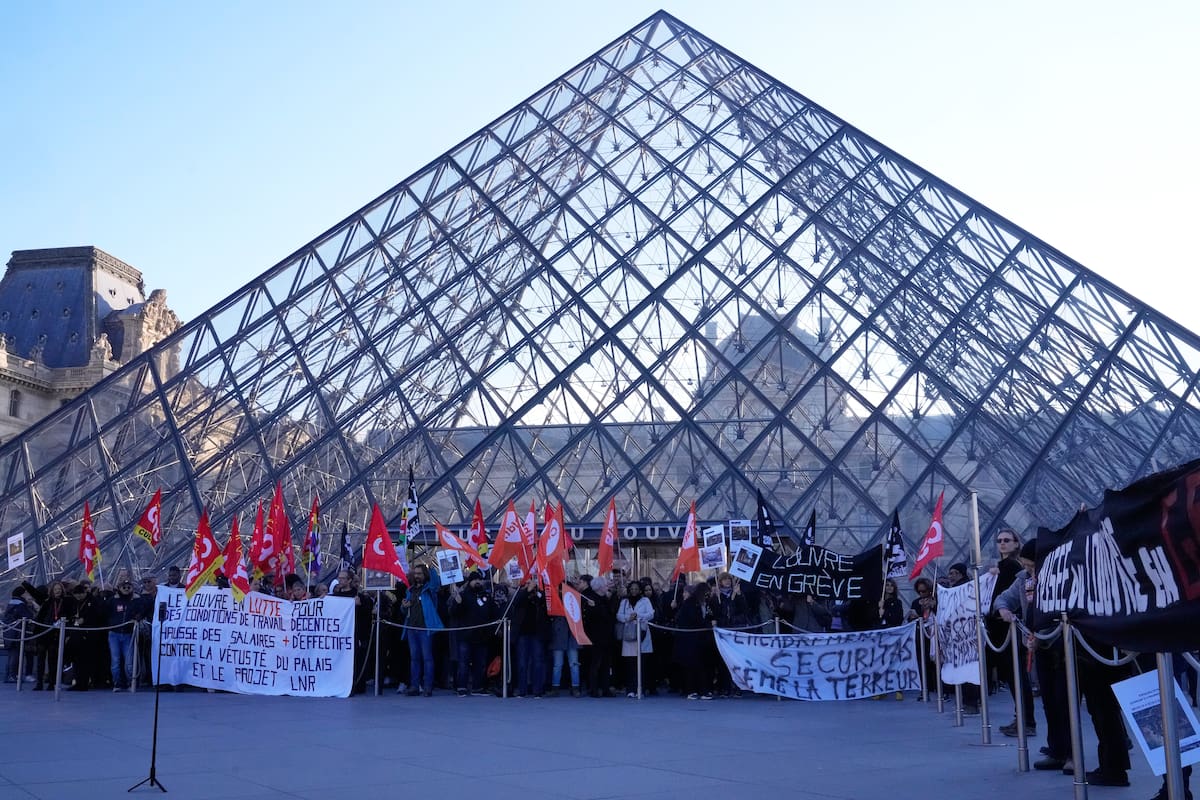 Trabajadores del Louvre en huelga exhiben pancartas frente al museo, el lunes 15 de diciembre de 2025 en París