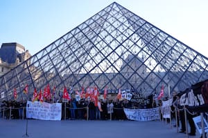 Trabajadores del Louvre en huelga exhiben pancartas frente al museo, el lunes 15 de diciembre de 2025 en París