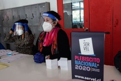 Trabajadores del Servicio Electoral de Chile (Servel) participan en un simulacro que muestra a la prensa las medidas de seguridad sanitaria de cara al referéndum del 25 de octubre