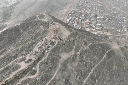 Trabajadores desmontan el conocido como "muro de la vergüenza", que divide una colina que separa un barrio acomodado de Lima de uno pobre, tras un pronunciamiento del Tribunal Constitucional en el que lo considera discriminatorio en Lima, Perú, el martes 5 de septiembre de 2023. (AP Foto/César Barreto)