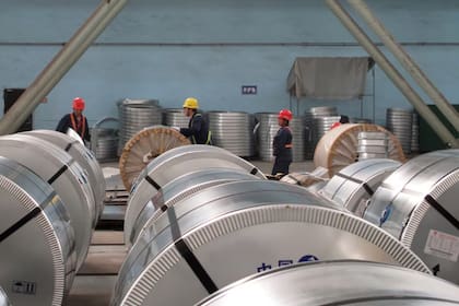Trabajadores empacan bobinas de acero laminado en frío en una empresa siderúrgica en Zhangjiagang, provincia de Jiangsu, China