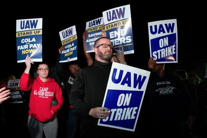 Trabajadores en huelga afiliados al sindicato United Auto Workers protestan frente a la Planta de Ensamblaje de Ford en Michigan el viernes 15 de septiembre de 2023, poco después de la medianoche, en Wayne, Michigan. (AP Foto/Paul Sancya)