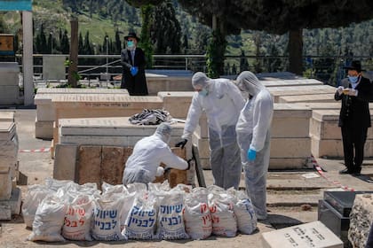 Trabajadores funerarios preparaban un cuerpo, ayer, en el cementerio HaMenuchot, de Jerusalén