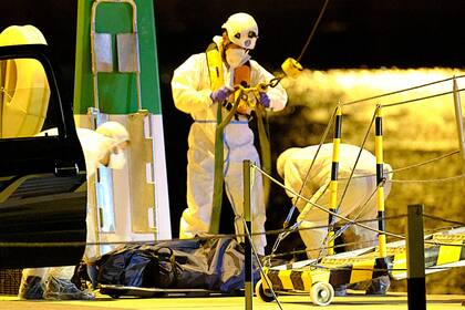 Trabajadores funerarios recogen los cuerpos de tres mujeres migrantes que murieron durante un naufragio cerca de Lanzarote, en las Islas Canarias, España, el miércoles 25 de agosto de 2021. (Europa Press vía AP)