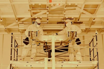 Trabajadores instalan un sistema automatizado de manejo de materiales dentro de la sala limpia o de ambiente controlado en la planta de fabricación de chips de Intel