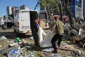 Trabajadores municipales trasladan el cuerpo de una persona fallecida tras el impacto de una bomba aérea rusa en Kharkiv, Ucrania