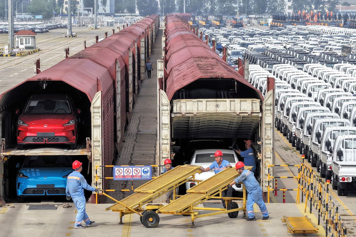 Trabajadores preparan autos para su envío en tren Yantai, en la provincia oriental china de Sandong, el 20 de junio de 2026. (Chinatopix via AP)