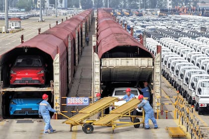 Trabajadores preparan autos para su envío en tren Yantai, en la provincia oriental china de Sandong, el 20 de junio de 2026